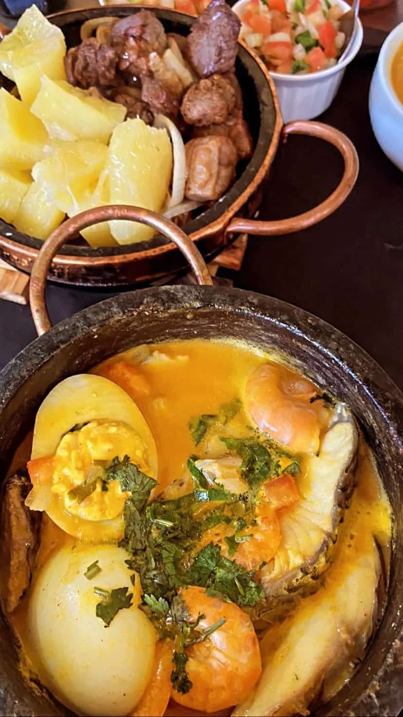 Moqueca de peixe com ovo e camarão na panela de pedra, com carne e mandioca