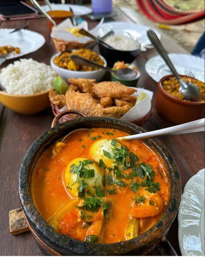 Mesa farta com moqueca na panela de pedra, peixe frito e arroz