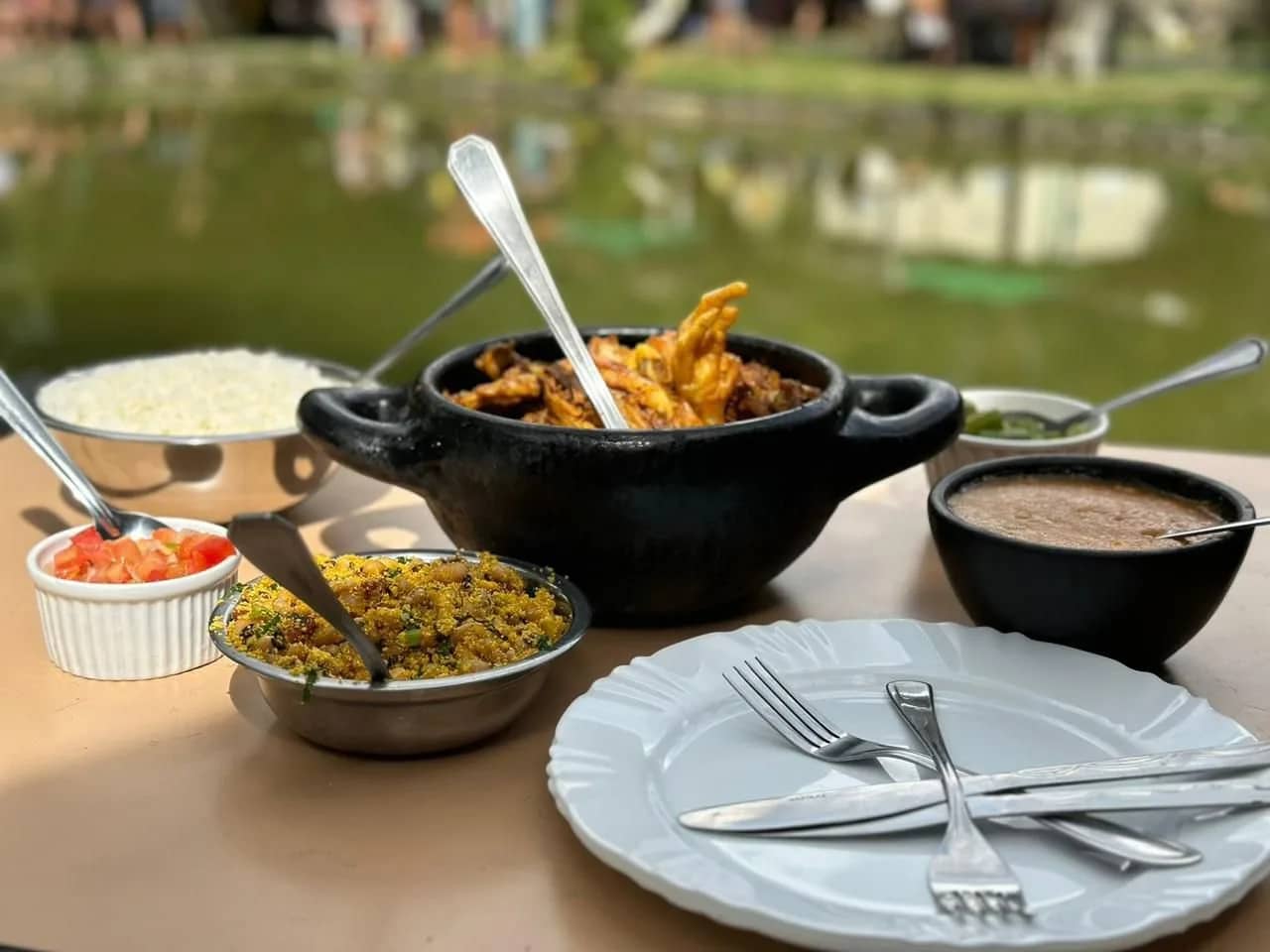 Almoço à beira da lagoa com peixe na panela, farofa, arroz e feijão