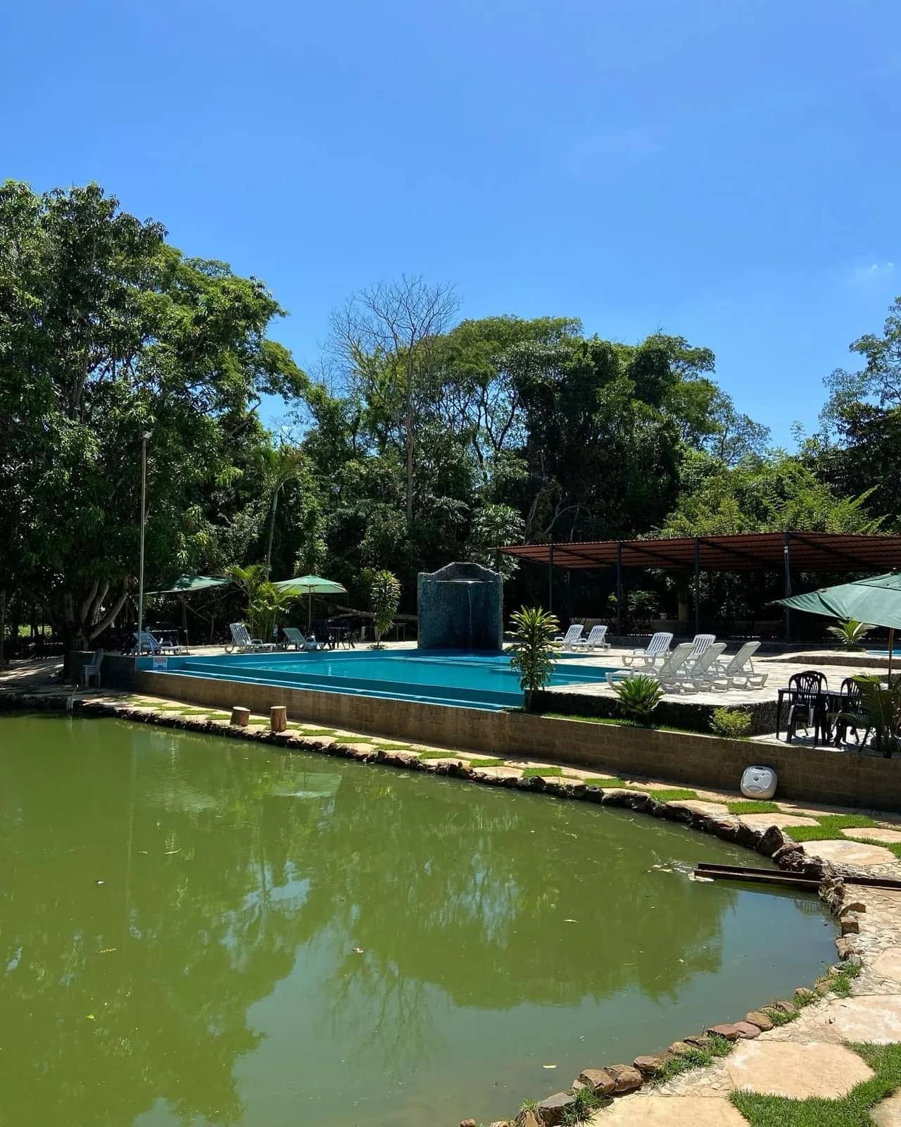 Vista ampla da lagoa com a piscina elevada e espreguiçadeiras ao fundo