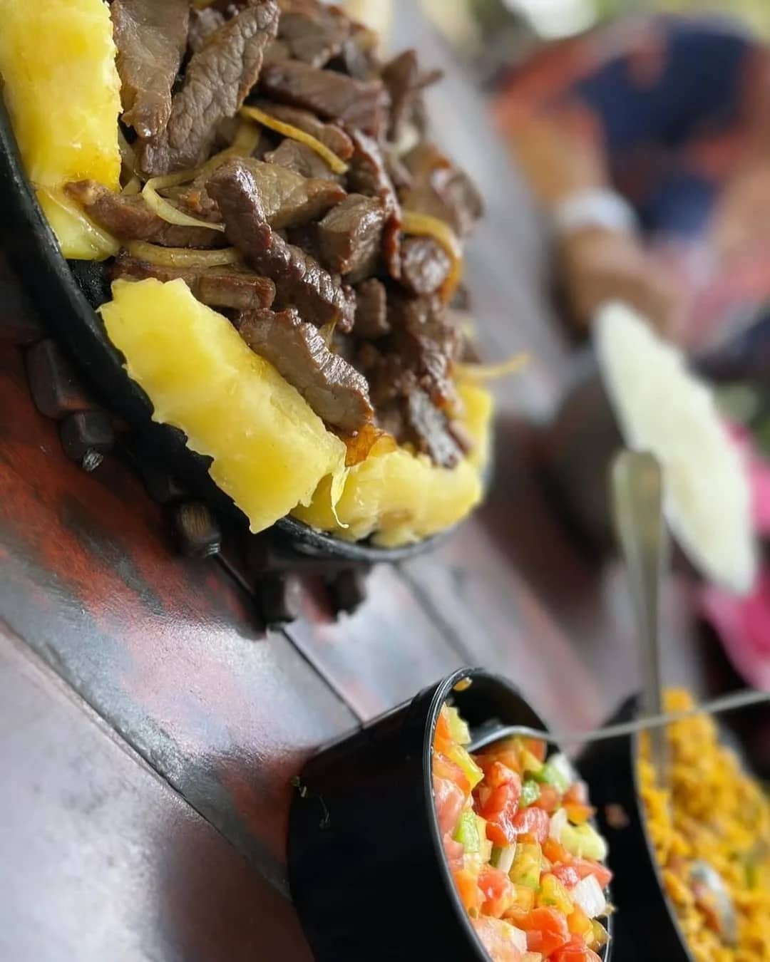 Carne de sol com mandioca cozida servida na panela de ferro com vinagrete
