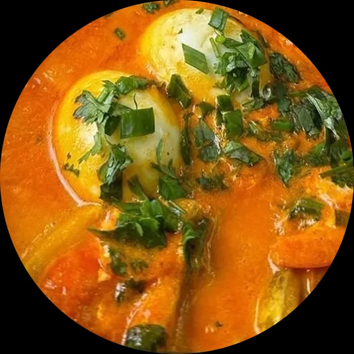 Moqueca de peixe com ovos e coentro fresco na panela de pedra